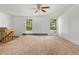 Bright living room with neutral carpeting and large windows offering ample natural light at 11199 Dahlia Pl, Thornton, CO 80233