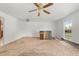 Bright living room features soft carpet, a ceiling fan, and a large window letting in ample natural light at 11199 Dahlia Pl, Thornton, CO 80233