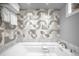 Modern bathroom featuring a soaking tub, decorative tiling, and neutral color palette at 2604 Elm St, Denver, CO 80207