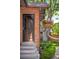 Charming front door with brick facade and garden with hanging flower basket at 2604 Elm St, Denver, CO 80207