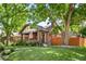 Charming brick home with a lush green lawn and mature trees providing ample shade and curb appeal at 2604 Elm St, Denver, CO 80207