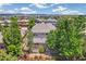 Aerial view showcases a home's backyard with a deck, mature trees and a scenic neighborhood at 3411 Springbriar Dr, Castle Rock, CO 80109