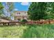 Backyard view of a tan two-story home with an open deck, pergola, and well-kept lawn at 3411 Springbriar Dr, Castle Rock, CO 80109