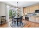 Charming breakfast nook with a round table and large window overlooking the backyard, complemented by custom cabinetry at 3411 Springbriar Dr, Castle Rock, CO 80109