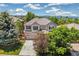 Two-story home features a well manicured front yard with mature trees and a neutral color scheme at 3411 Springbriar Dr, Castle Rock, CO 80109