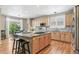 Modern kitchen featuring wood cabinets, granite counters, a center island with bar seating, and stainless appliances at 3411 Springbriar Dr, Castle Rock, CO 80109
