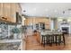 Bright kitchen featuring wood cabinets, an island with bar seating, granite counters, and stainless appliances at 3411 Springbriar Dr, Castle Rock, CO 80109