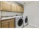 Practical laundry room with upper cabinets, a sink, and modern LG washer and dryer at 3411 Springbriar Dr, Castle Rock, CO 80109