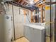 Basement with a laundry setup, water heater, and visible ceiling beams at 10415 Owens Cir, Broomfield, CO 80021