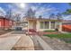 Well-lit exterior showcasing a charming single-story home with a covered carport and brick accents at 4940 Adams St, Denver, CO 80216