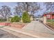 View of the front of this home, showcasing well-maintained landscaping and secure gated driveway at 4940 Adams St, Denver, CO 80216