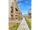 Three-story townhome with charming architectural details and exterior stone accents alongside a sidewalk at 11250 Florence St # 21A, Commerce City, CO 80640