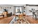 Open-concept living space with hardwood floors, featuring a dining table and chairs adjacent to the living area at 11250 Florence St # 21A, Commerce City, CO 80640