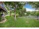 Expansive backyard featuring a lush lawn, mature trees, and a charming white picket fence creating a serene outdoor space at 2480 W Jamison Way, Littleton, CO 80120