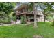 Multi-level backyard with patio, lawn, mature trees, and lush landscaping creating an inviting and private outdoor oasis at 2480 W Jamison Way, Littleton, CO 80120