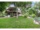 Spacious backyard featuring a lush lawn, mature trees, and a white picket fence creating a serene outdoor space at 2480 W Jamison Way, Littleton, CO 80120