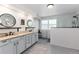 Modern bathroom features dual sinks, granite countertops, sleek cabinetry, and a glass-enclosed shower at 2480 W Jamison Way, Littleton, CO 80120