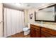 Bathroom with granite countertops, wood cabinets, tiled floors, and shower with white curtain at 2480 W Jamison Way, Littleton, CO 80120