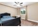 Bedroom featuring neutral color scheme, a ceiling fan, a window, a dark bed, and tan carpet at 2480 W Jamison Way, Littleton, CO 80120