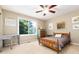Cozy bedroom with a large window offering natural light, complimented by a ceiling fan at 2480 W Jamison Way, Littleton, CO 80120