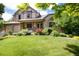 Charming two-story home with a stone facade, manicured lawn, and colorful flower beds at 2480 W Jamison Way, Littleton, CO 80120