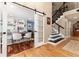 Hallway featuring hardwood floors, white trim, nearby office with barn door, and stairs at 2480 W Jamison Way, Littleton, CO 80120