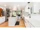Bright, open kitchen with white cabinets, center island, and stainless steel appliances at 2480 W Jamison Way, Littleton, CO 80120