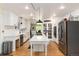 Open kitchen featuring white cabinets, center island, and stainless appliances at 2480 W Jamison Way, Littleton, CO 80120
