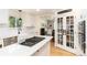 Bright kitchen with white cabinets, an island cooktop, and stainless appliances at 2480 W Jamison Way, Littleton, CO 80120