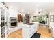 Spacious kitchen featuring white cabinets, stainless appliances and a center island with cooktop at 2480 W Jamison Way, Littleton, CO 80120