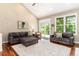 Open living room featuring vaulted ceilings, hardwood floors, and a sliding door to the deck at 2480 W Jamison Way, Littleton, CO 80120