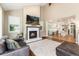 Open living room with a fireplace, hardwood floors, and view to the kitchen at 2480 W Jamison Way, Littleton, CO 80120