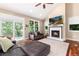 Cozy living room with a fireplace, hardwood floors, access to the deck, and natural light at 2480 W Jamison Way, Littleton, CO 80120