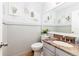 Stylish powder room featuring paneled walls, leaf art, granite vanity, and modern fixtures at 2480 W Jamison Way, Littleton, CO 80120