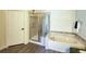 Bright bathroom featuring a glass shower, soaking tub, and neutral tile accents at 13708 Legend Trl # 101, Broomfield, CO 80023