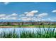 Beautiful exterior community view of homes near a lake with a mountain range in the background under a partly cloudy blue sky at 13708 Legend Trl # 101, Broomfield, CO 80023