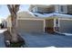 Attached garage with driveway and stone accents on exterior at 13708 Legend Trl # 101, Broomfield, CO 80023