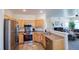 Bright kitchen featuring stainless steel appliances, wood cabinets and a breakfast bar area at 13708 Legend Trl # 101, Broomfield, CO 80023