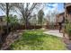 Spacious backyard featuring lush green grass, mature trees, and a charming patio area at 9195 Anasazi Indian Trl, Highlands Ranch, CO 80129