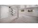 Open basement area with neutral carpet, bright walls, built-in shelving, and natural light from two windows at 9195 Anasazi Indian Trl, Highlands Ranch, CO 80129