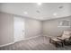 Clean basement with carpet, chair with footstool, and white door at 9195 Anasazi Indian Trl, Highlands Ranch, CO 80129