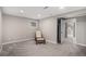 Finished basement with carpet, chair with footstool, and open closet space at 9195 Anasazi Indian Trl, Highlands Ranch, CO 80129