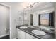 Well-lit bathroom featuring a double vanity, a large mirror, and a separate shower and tub at 9195 Anasazi Indian Trl, Highlands Ranch, CO 80129
