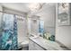 Bright bathroom featuring a shower-tub combo, granite vanity, and a decorative shower curtain at 9195 Anasazi Indian Trl, Highlands Ranch, CO 80129