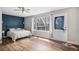 Bright bedroom featuring a large window, wood floors, a ceiling fan, and a neutral color scheme at 9195 Anasazi Indian Trl, Highlands Ranch, CO 80129