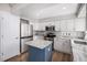 Beautiful kitchen with stainless steel appliances, white cabinets, and a contrasting blue island at 9195 Anasazi Indian Trl, Highlands Ranch, CO 80129