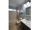 Bathroom featuring a shower-tub combo, single sink vanity, and neutral-toned tile at 1137 S Coolidge Cir, Aurora, CO 80018