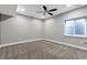 An empty carpeted bedroom features a ceiling fan, a window, and a utility access in the ceiling at 7426 Blue Water Ln, Castle Rock, CO 80108