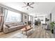 Bright, open living area with wood floors, neutral walls, a ceiling fan, and a seamless flow into the dining and kitchen spaces at 7426 Blue Water Ln, Castle Rock, CO 80108