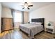 Serene main bedroom featuring wood floors, a ceiling fan, and a bright window for natural light at 7426 Blue Water Ln, Castle Rock, CO 80108